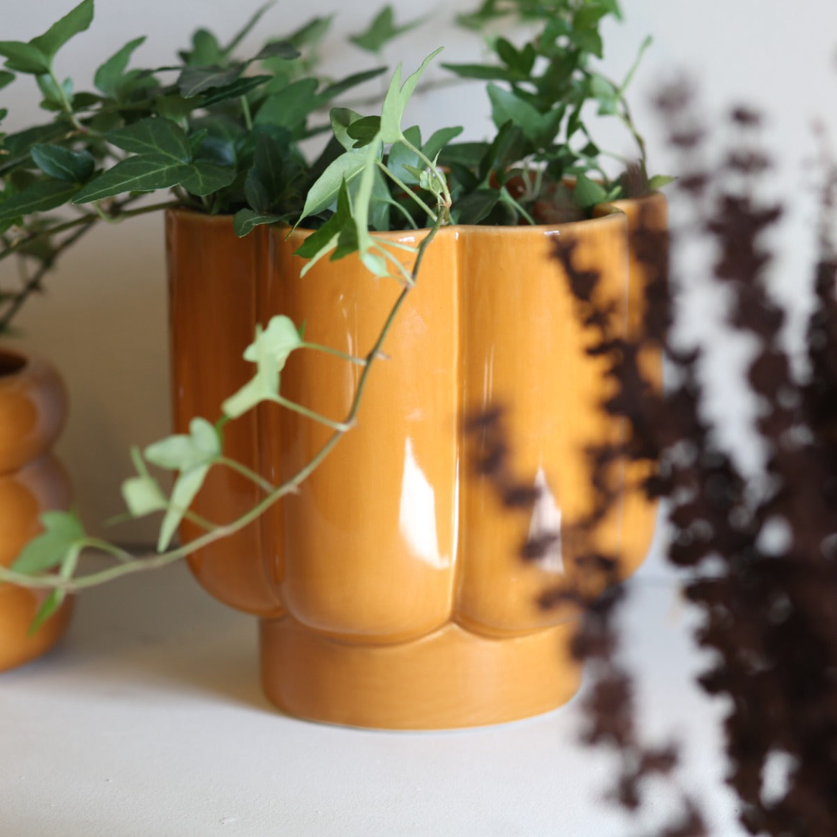Senapsgul blomformad keramikkruka med gröna växter – Krukor & Rum